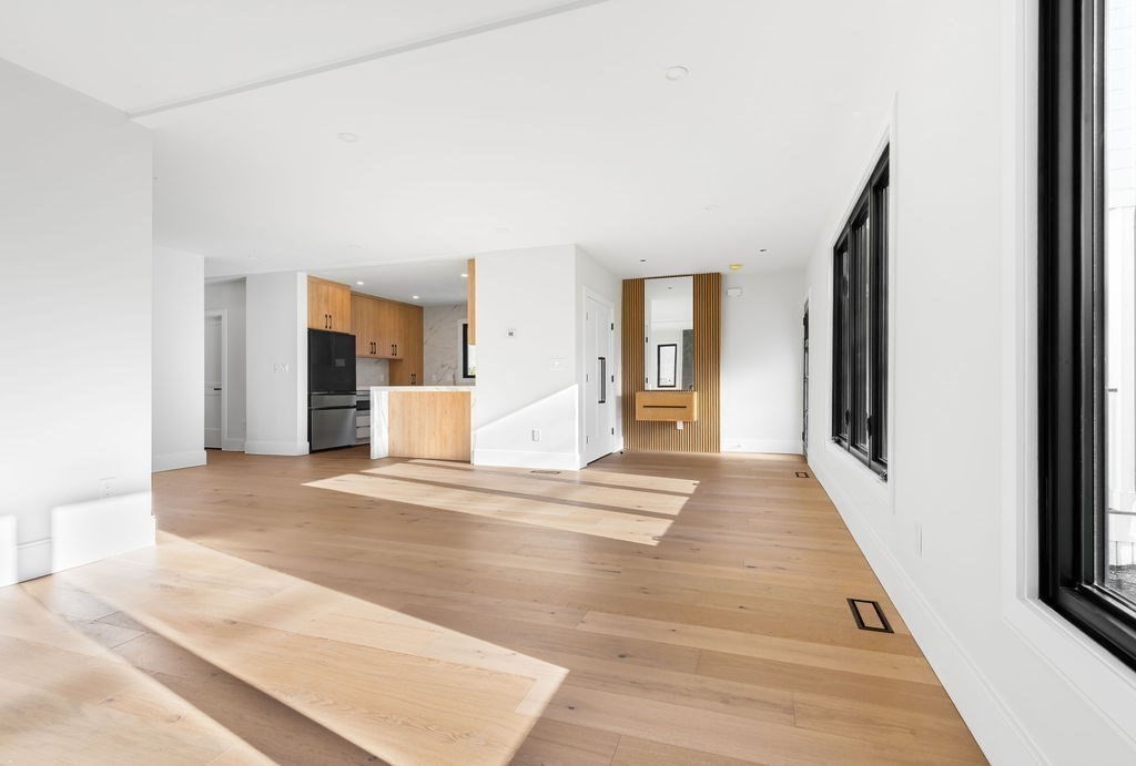 265-267 River Street, Unit 267 Newton, MA 02465 - Photo 6 of 22 a view of a hallway with wooden floor and a living room