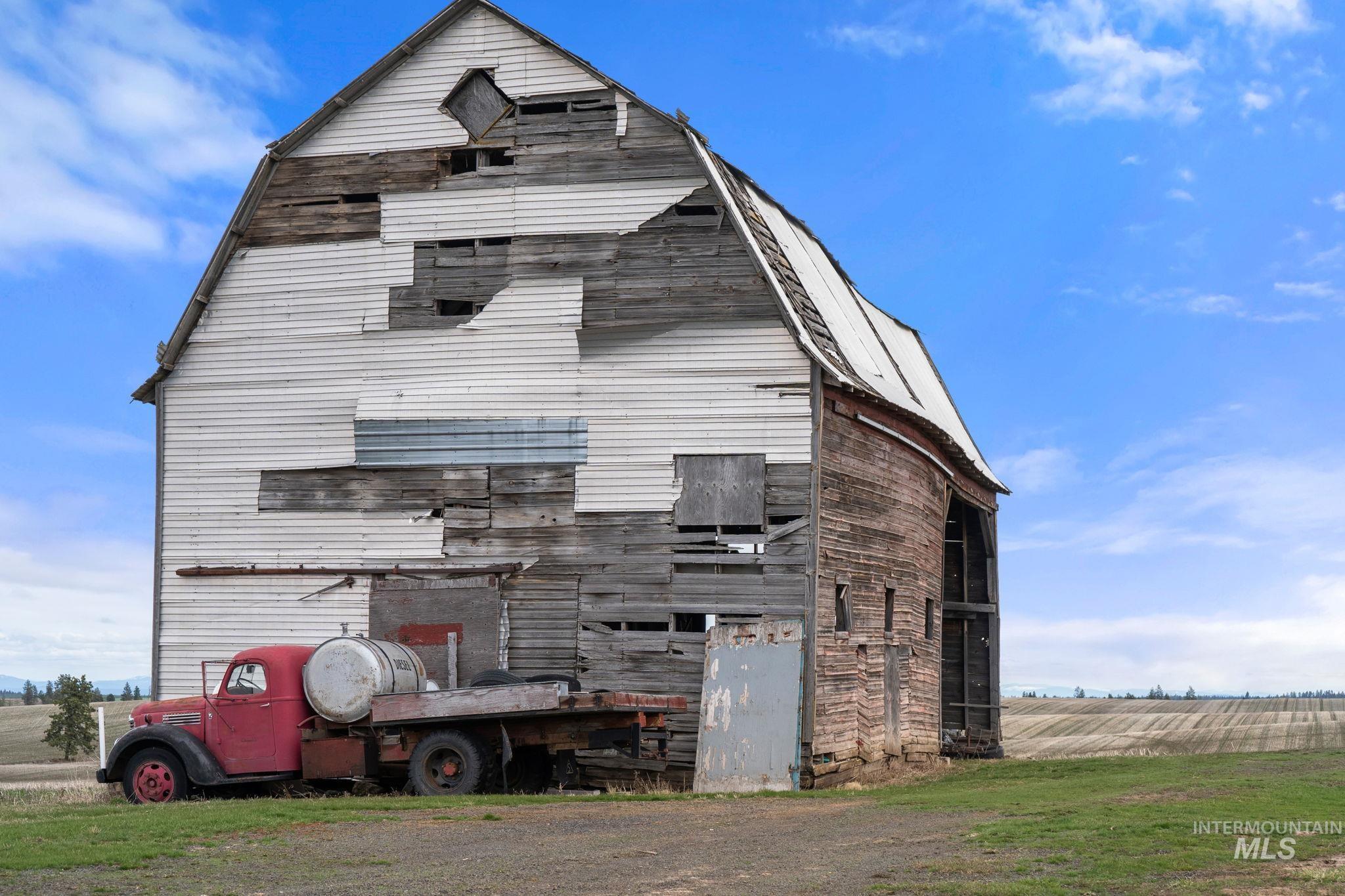 2326 Reubens Road Reubens, ID 83548 - Photo 16 of 34 Rear view of house with a gambrel roof, a barn, an outdoor structure, and a view of rural / pastoral area
