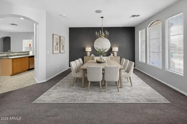 a view of a livingroom with a chandelier fan and windows