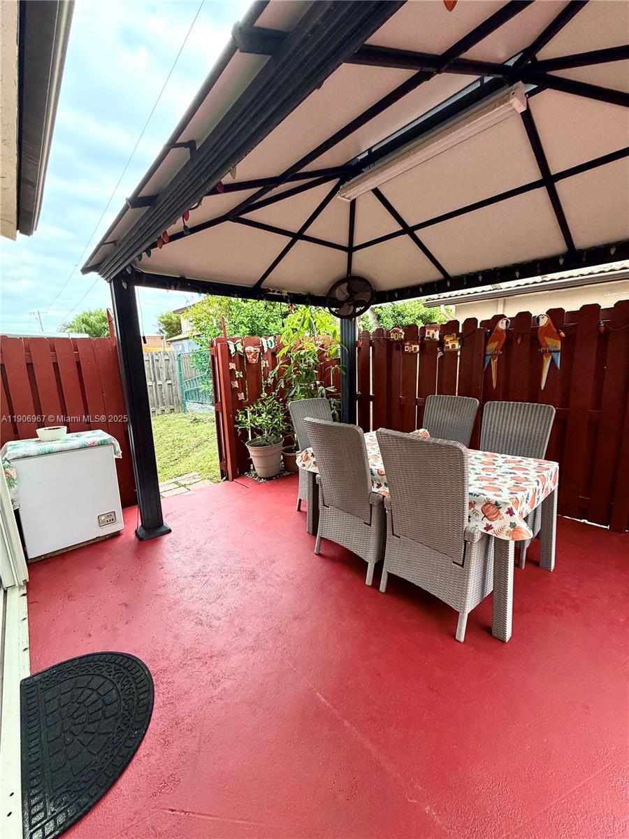 13778 Southwest 170th Lane Miami, FL 33177 - Photo 23 of 23 a view of patio with table and chairs under an umbrella