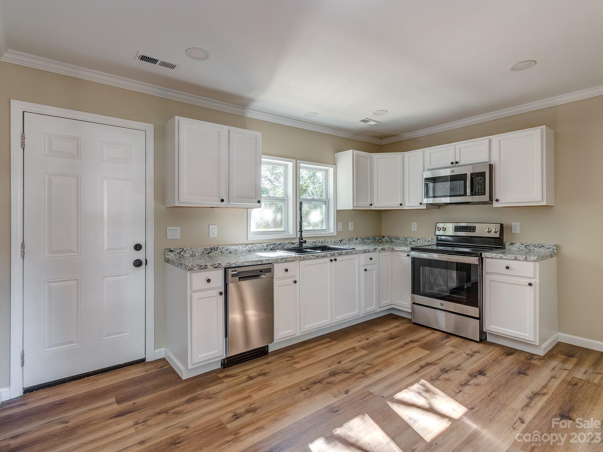 1031 State Rd S-29-424 Lancaster, SC 29720 - Photo 5 of 47 a kitchen with granite countertop white cabinets and white appliances