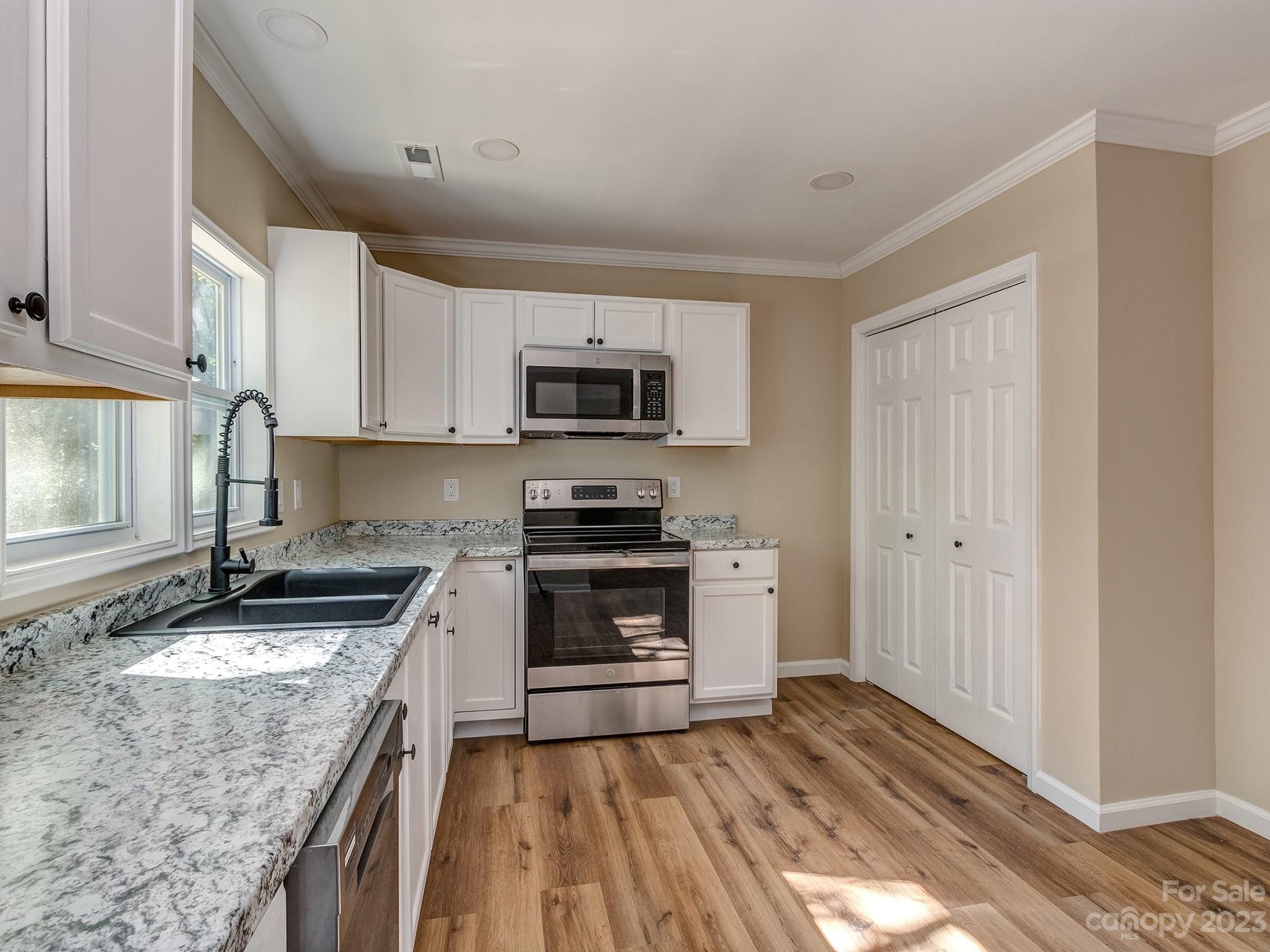 1031 State Rd S-29-424 Lancaster, SC 29720 - Photo 7 of 47 a kitchen with granite countertop a stove top oven a sink dishwasher and a refrigerator with wooden floor