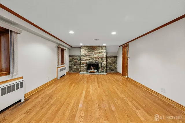 a big room with wooden floor and fireplace