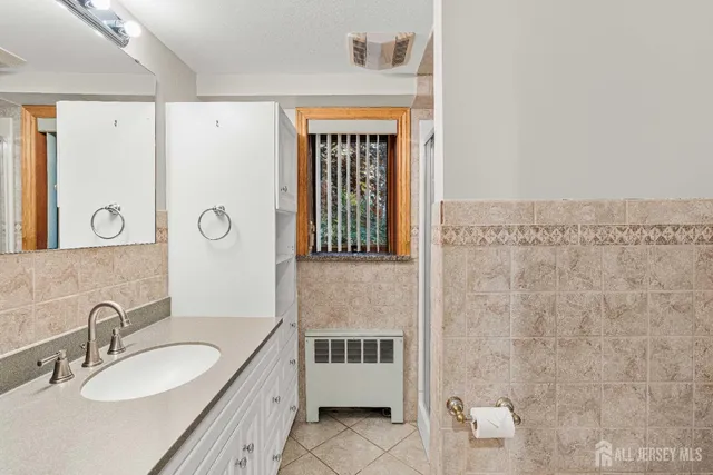 a en suite bathroom with a granite countertop sink and a mirror