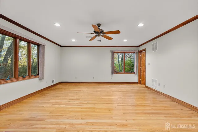 a view of an empty room with window and a ceiling fan