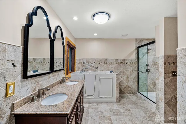a bathroom with a granite countertop sink a mirror and shower