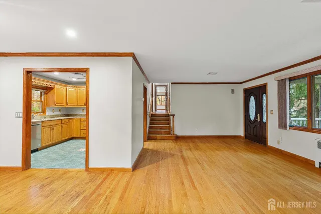 a view of an empty room with window and wooden floor