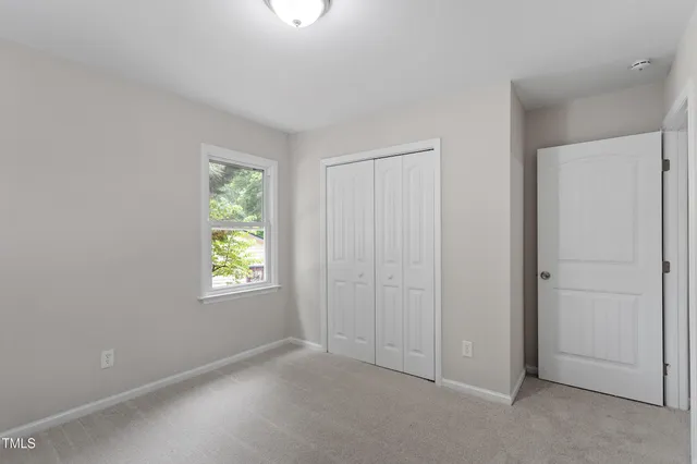 an empty room with windows and closet