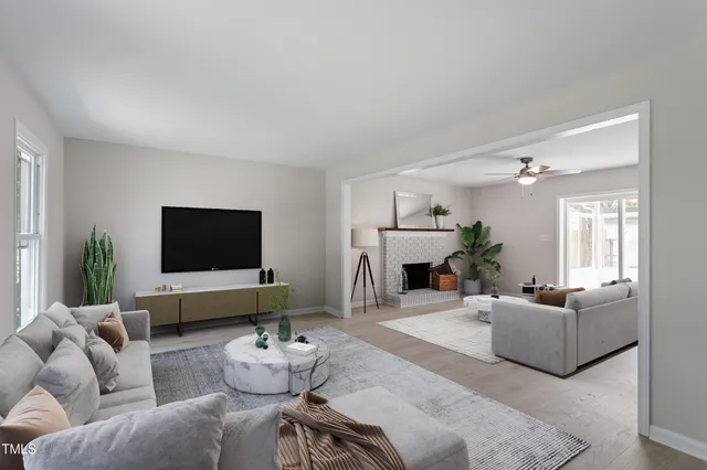 a living room with furniture a fireplace and a flat screen tv