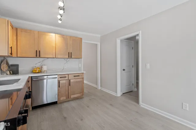 a kitchen with stainless steel appliances granite countertop a stove a sink and a refrigerator with wooden floors