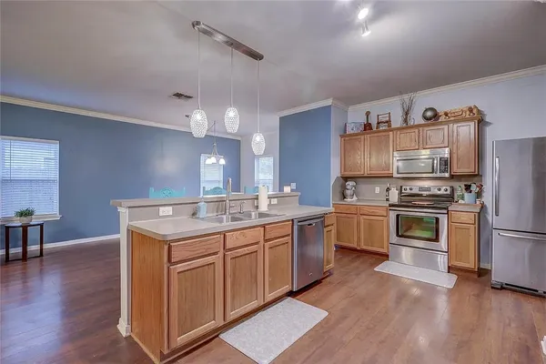 a kitchen with granite countertop a sink cabinets and stainless steel appliances