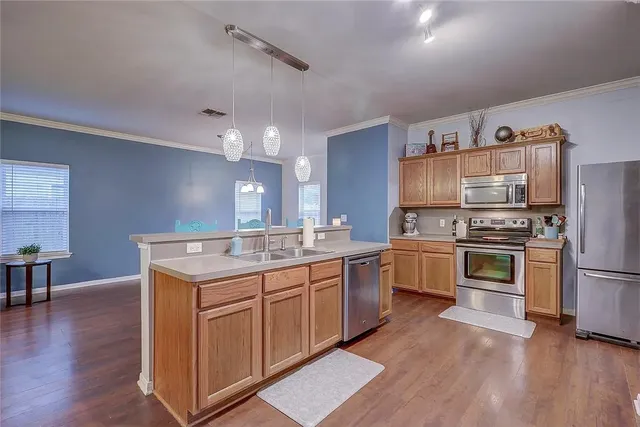 a kitchen with granite countertop a sink cabinets and stainless steel appliances