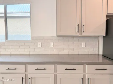 a kitchen with granite countertop white cabinets and a sink