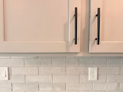a view of a kitchen with white cabinets