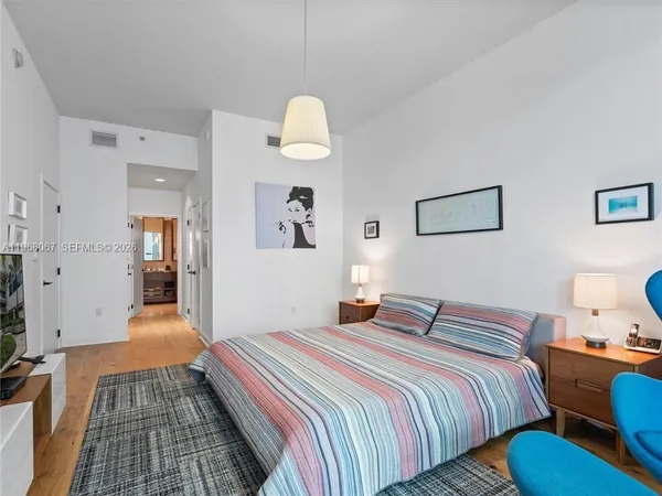 a bedroom with bed and wooden floor