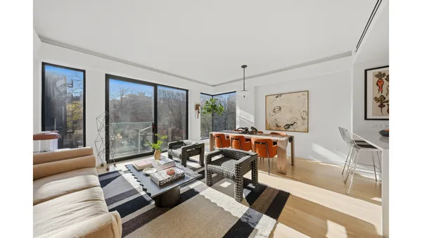 a living room with furniture and a floor to ceiling window