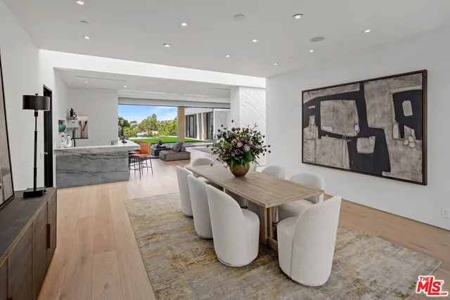 a kitchen with stainless steel appliances granite countertop a stove a refrigerator a kitchen island a table and chairs in it