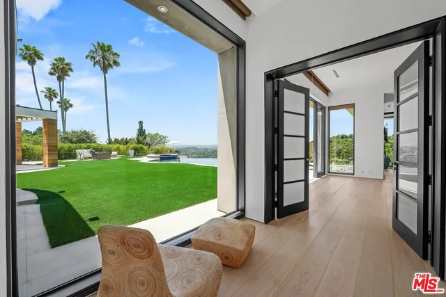 a living room with couch floor to ceiling window and wooden floor