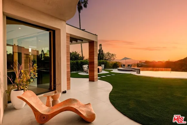 a swimming pool with outdoor seating and a garden