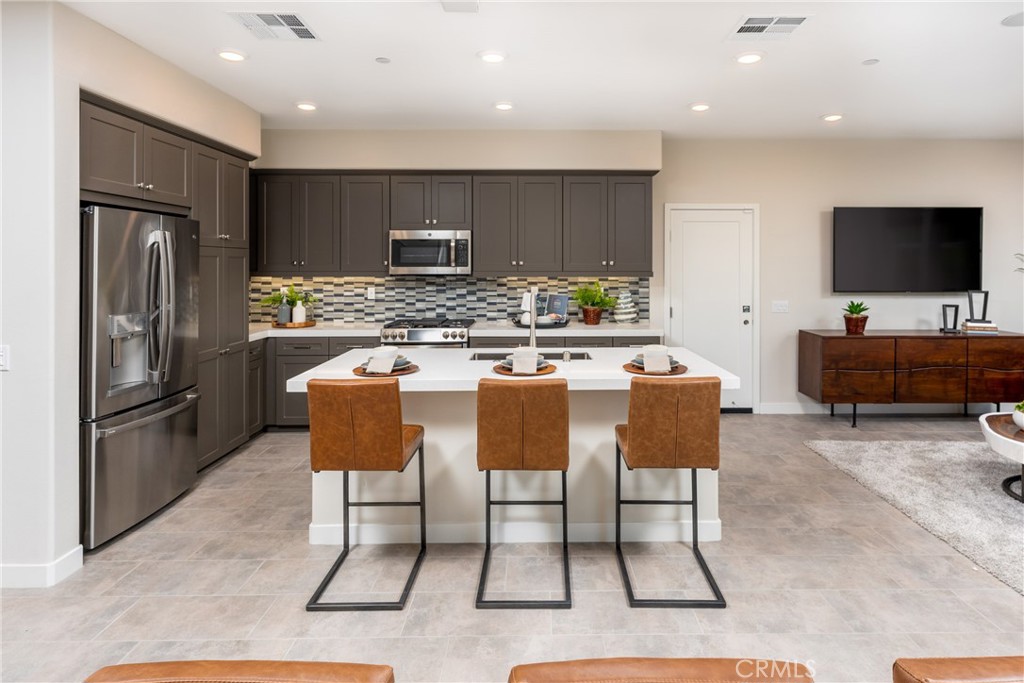 263 Siena Lake Forest, CA 92630 - Photo 4 of 51 a kitchen with stainless steel appliances kitchen island granite countertop a refrigerator and a stove top oven