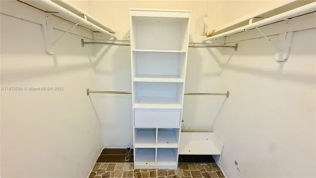 a view of walk in closet with empty racks