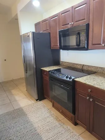 a kitchen with granite countertop a stove and a microwave