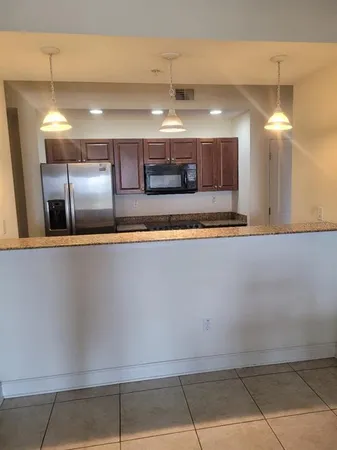 a large kitchen with a large counter top and kitchen view