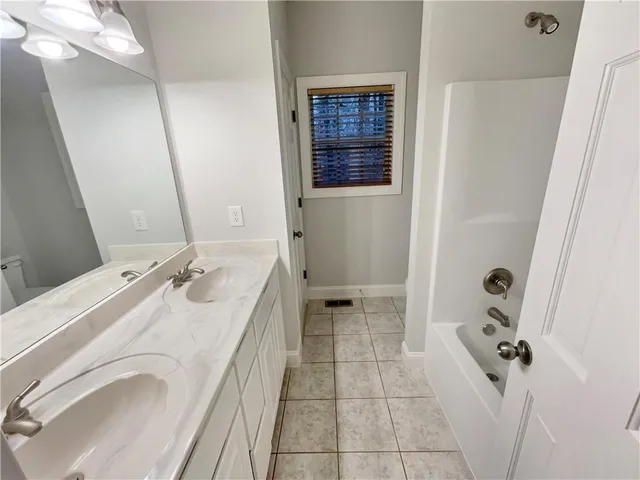 a bathroom with a granite countertop sink a mirror and shower