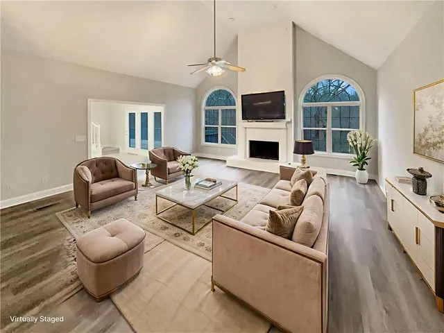 a living room with furniture a fireplace and a chandelier