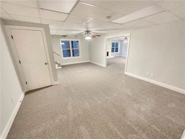 en empty room with windows and ceiling fan