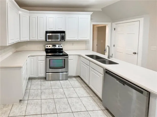 a kitchen with a sink stainless steel appliances and cabinets