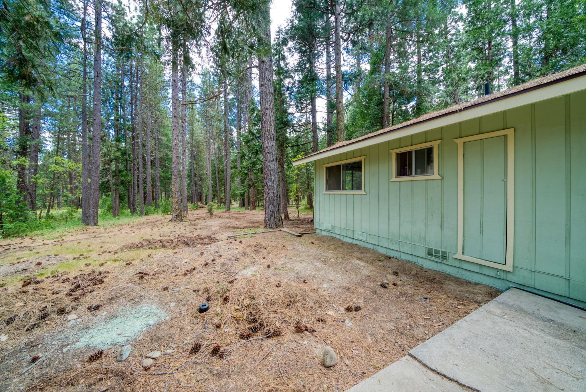 58374 Gill Ranch Road Cromberg, CA 96103 - Photo 16 of 44 a backyard of a house with large trees and wooden fence
