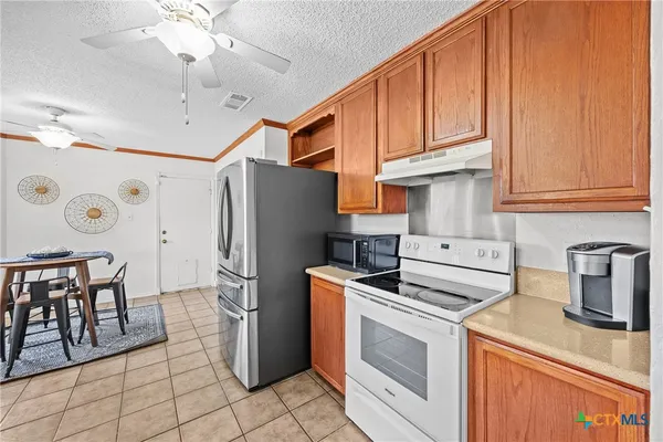 a kitchen with stainless steel appliances a stove a refrigerator and cabinets