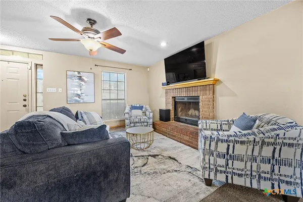 a living room with furniture a flat screen tv and a fireplace