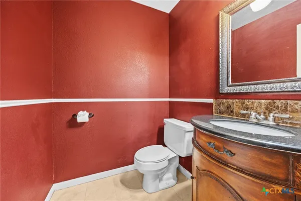 a bathroom with a toilet a sink and mirror