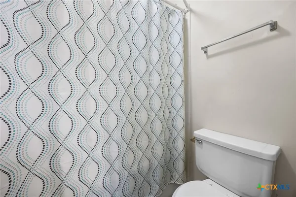 a white toilet sitting next to a white wall