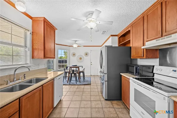 a kitchen with a sink a refrigerator and cabinets