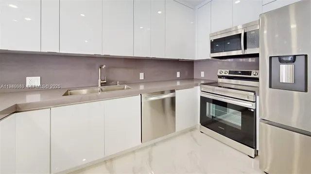 a kitchen with stainless steel appliances granite countertop a refrigerator sink and microwave