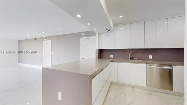 a kitchen with stainless steel appliances white cabinets and a refrigerator