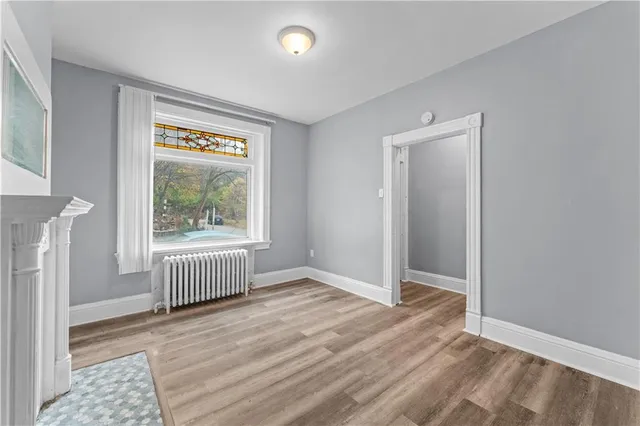 an empty room with wooden floor and a window