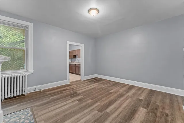wooden floor in an empty room with a window
