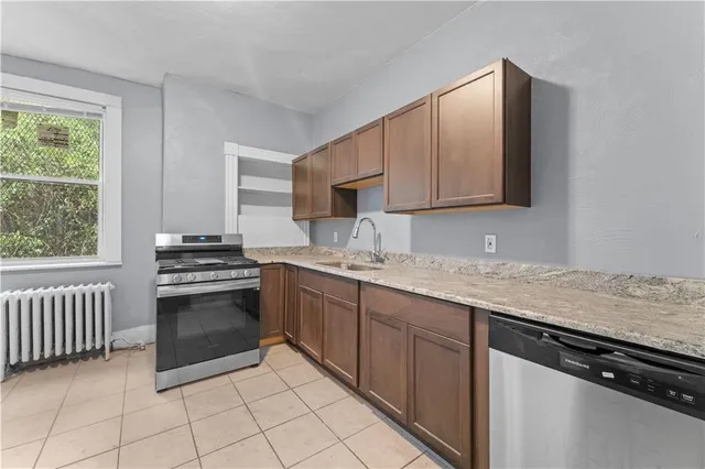 a kitchen with granite countertop a sink stove and cabinets