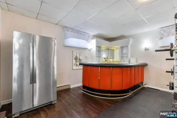 a room with stainless steel appliances wooden floor and chandelier
