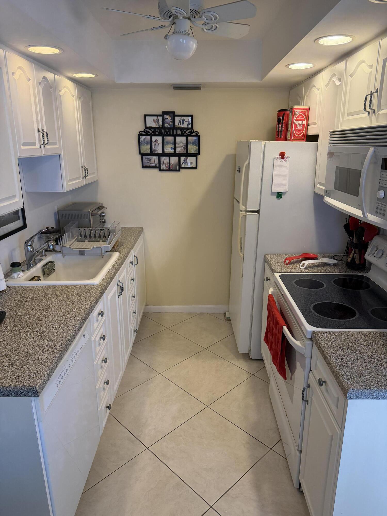 4042 Exeter C Boca Raton, FL 33434 - Photo 2 of 13 a kitchen with stainless steel appliances granite countertop a sink stove and refrigerator