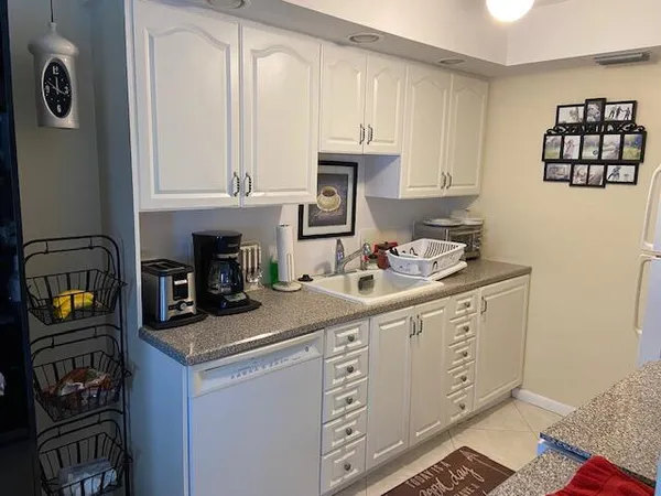 a kitchen with granite countertop a sink stove and cabinets