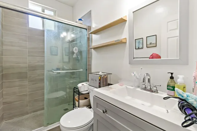 a bathroom with a sink a toilet and shower