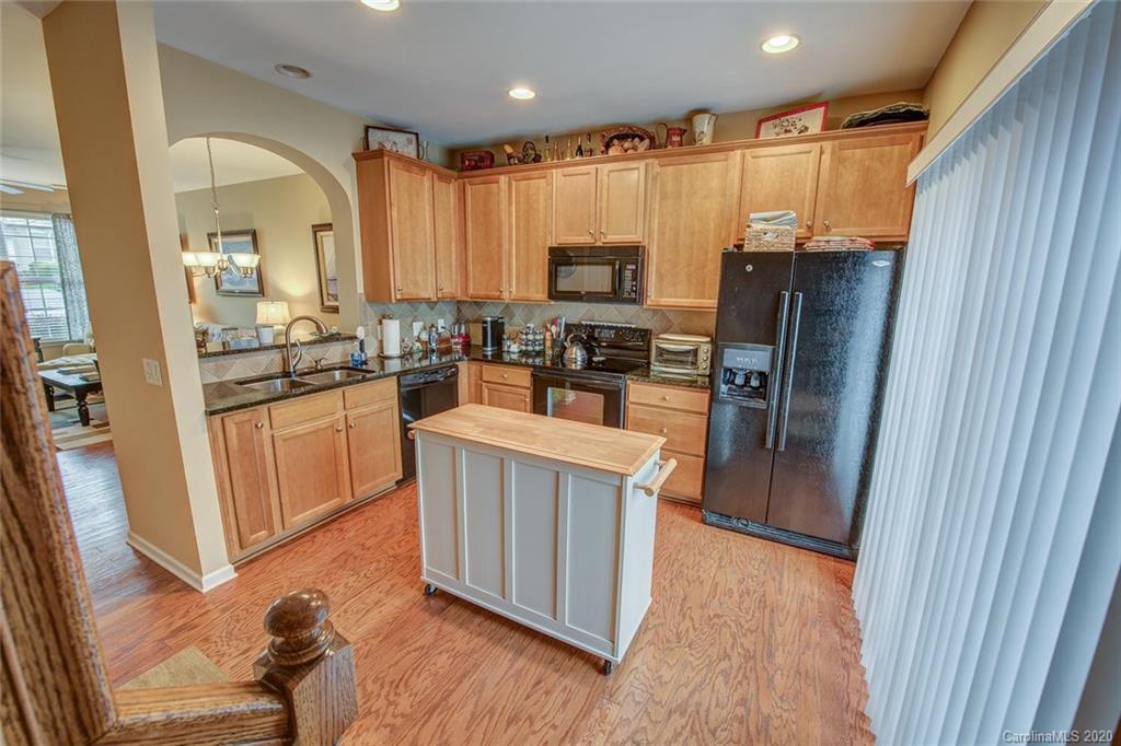 220 Falling Ridge, Unit 149 Mount Holly, NC 28012 - Photo 8 of 19 a kitchen with stainless steel appliances a refrigerator a sink a stove a microwave and wooden floors