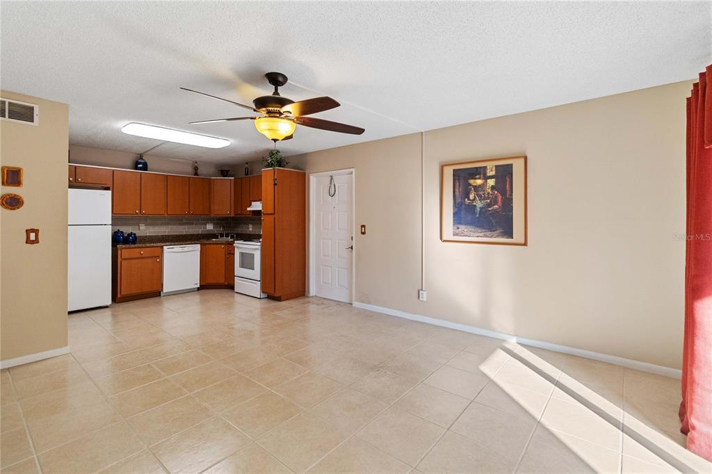 8205 Sun Spring Circle, Unit C2 Orlando, FL 32825 - Photo 4 of 18 a view of a kitchen with a stove cabinets a ceiling fan and wooden floor