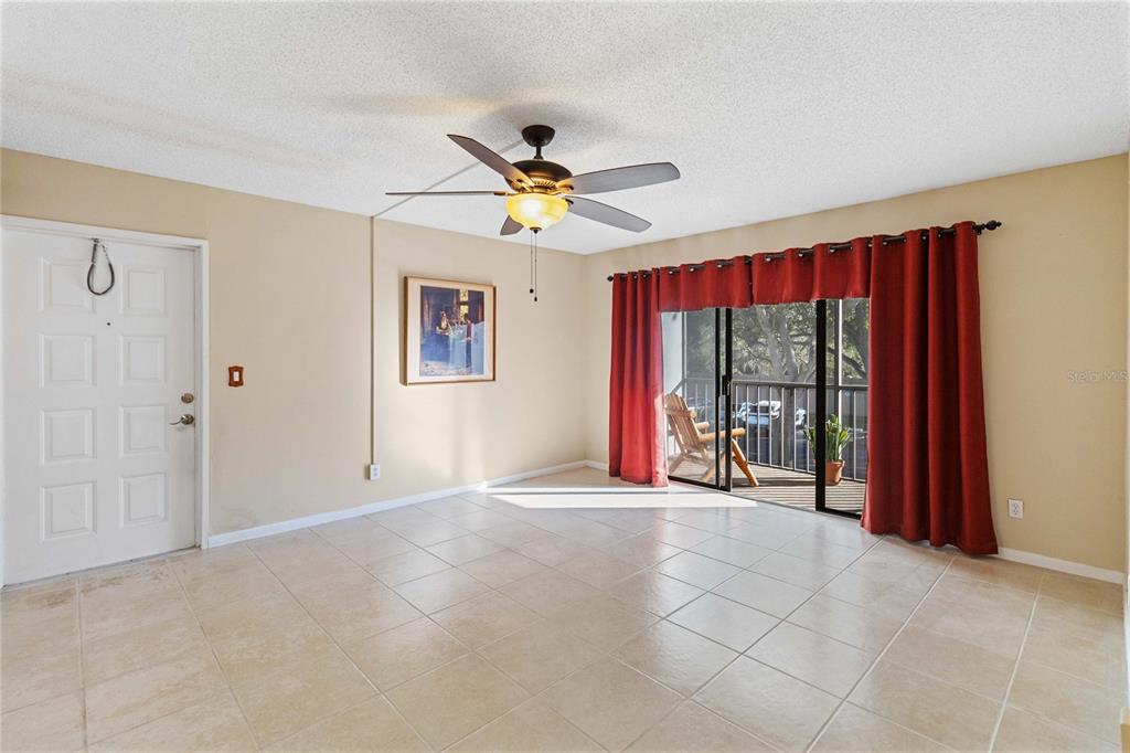 8205 Sun Spring Circle, Unit C2 Orlando, FL 32825 - Photo 5 of 18 a view of an empty room with a ceiling fan and a large window