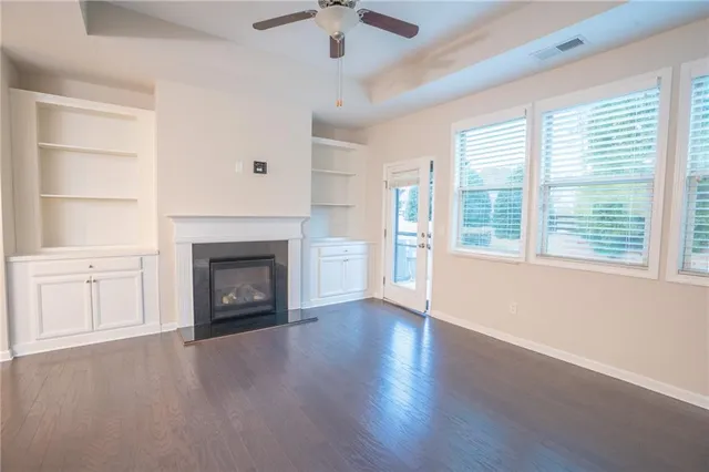 an empty room with windows and a fireplace